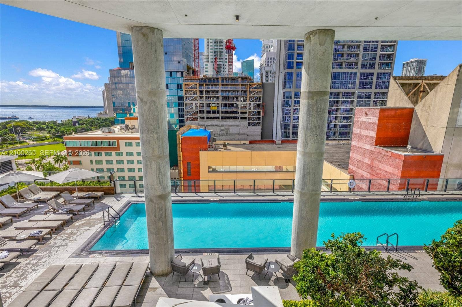 398 NE 5th Street, #2219, Miami, FL 33132 Outdoor swimming pool featuring a concrete terrace, structural support columns, and metal railings