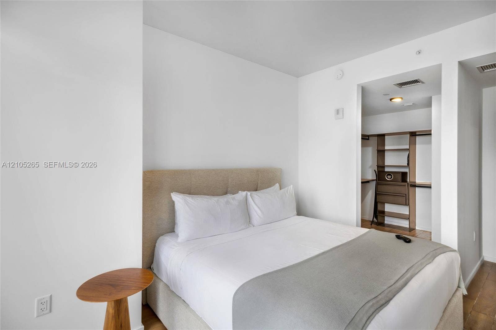 398 NE 5th Street, #2219, Miami, FL 33132 Neutral-toned upholstered headboard with recessed lighting and walk-in closet featuring integrated shelving