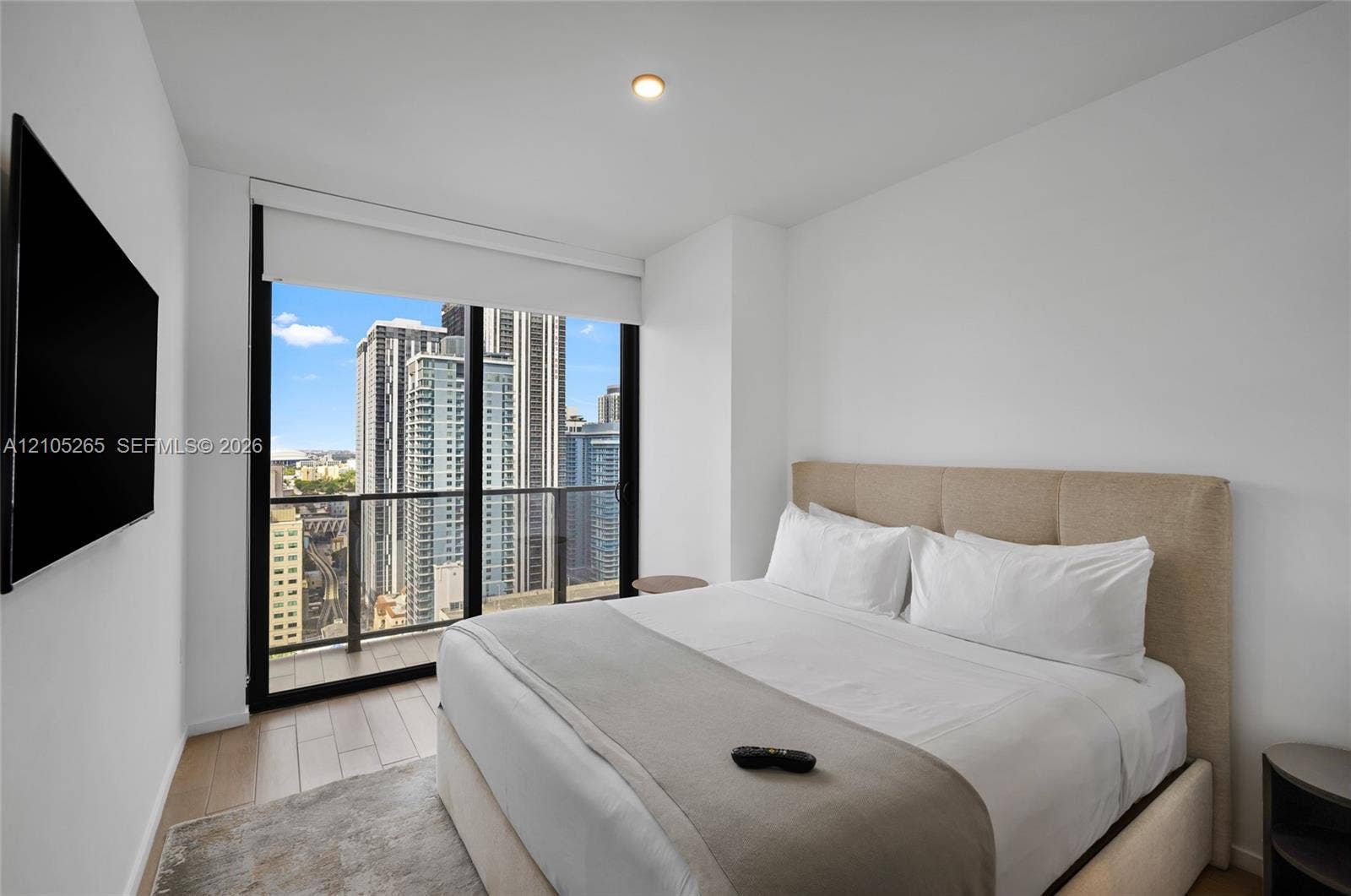 398 NE 5th Street, #2219, Miami, FL 33132 Floor-to-ceiling windows featuring urban skyline scenery, integrated glass-panel balcony, and wood-finish flooring