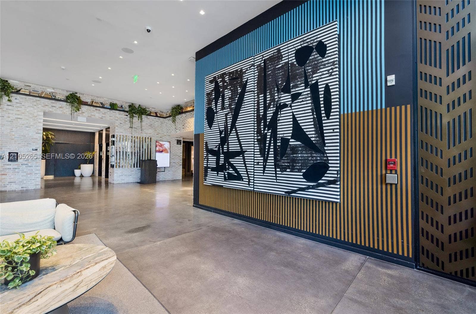 398 NE 5th Street, #2219, Miami, FL 33132 Lobby featuring polished concrete flooring, stacked stone wall accents, and vertical slatted wood wall paneling