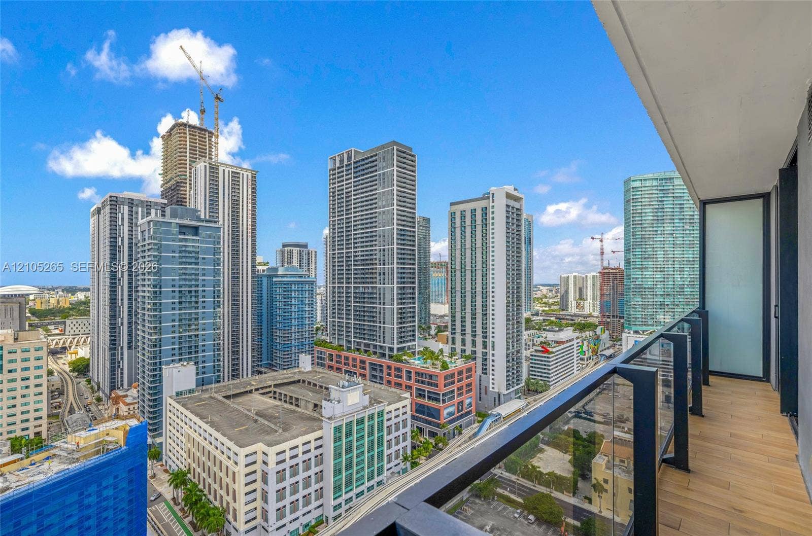 398 NE 5th Street, #2219, Miami, FL 33132 Private balcony with wood-finish flooring, glass and matte black metal railing, and cityscape panorama