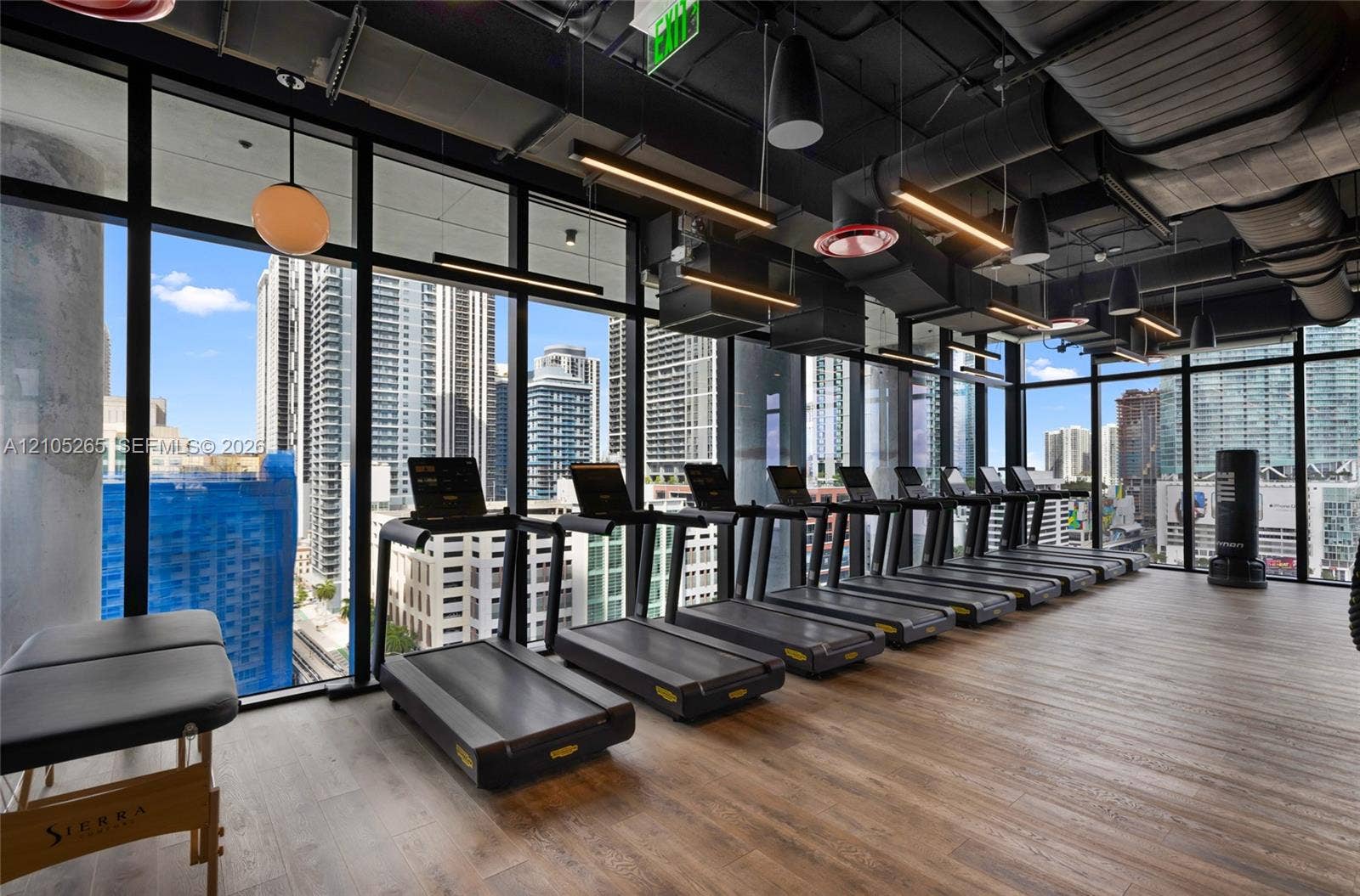 398 NE 5th Street, #2219, Miami, FL 33132 Fitness center featuring floor-to-ceiling windows, wood-finish flooring, exposed industrial-style ductwork, and suspended linear lighting