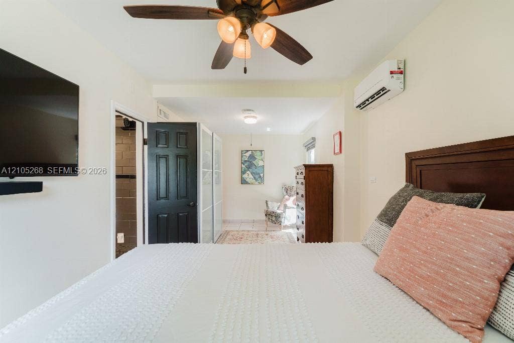 230 Miami Springs Avenue, Miami Springs, FL 33166 Ceiling fan with integrated lighting, wall-mounted air conditioning unit, and wood-finish headboard