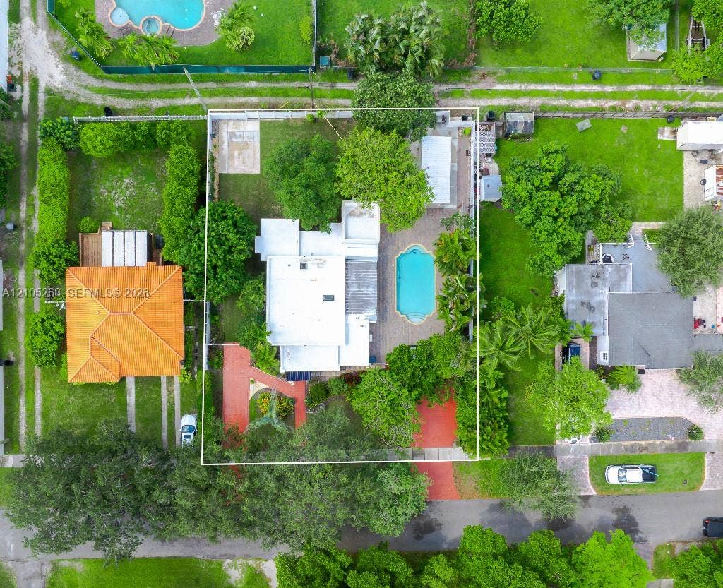 230 Miami Springs Avenue, Miami Springs, FL 33166 Aerial perspective showcasing a property with a swimming pool, mature landscaping, and a substantial lot size