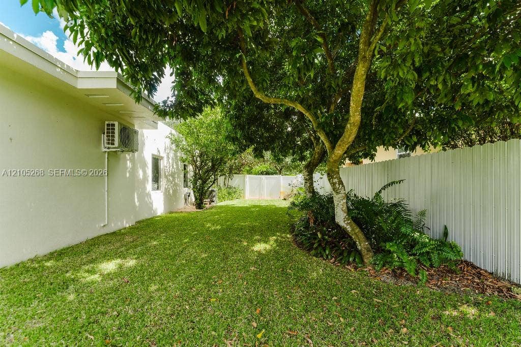 230 Miami Springs Avenue, Miami Springs, FL 33166 Expansive lawn area with mature trees and perimeter fencing