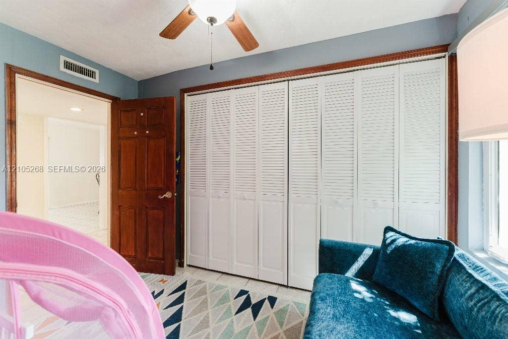 230 Miami Springs Avenue, Miami Springs, FL 33166 Wood-finish ceiling fan, recessed lighting, wood-finish paneled door, and white louvered bifold closet doors