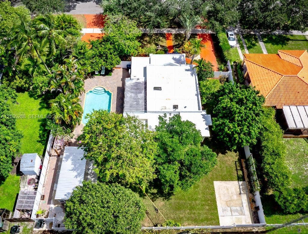 230 Miami Springs Avenue, Miami Springs, FL 33166 Rectangular residence with a flat roof, surrounded by mature trees and lush landscaping