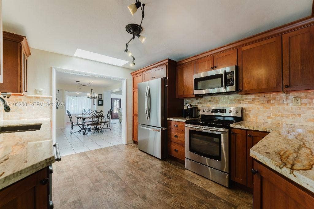 230 Miami Springs Avenue, Miami Springs, FL 33166 Wood-finish flooring with a skylight, full suite of stainless steel appliances, and stone countertops
