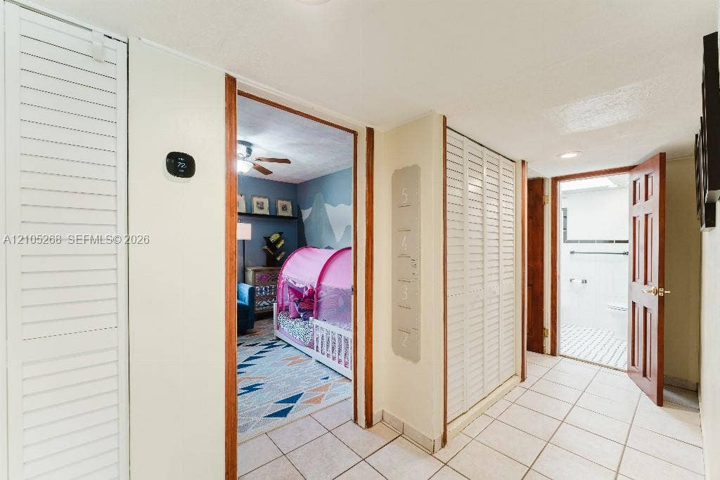 230 Miami Springs Avenue, Miami Springs, FL 33166 Hallway featuring tile flooring, louvered closet doors, and wood-finish door frames
