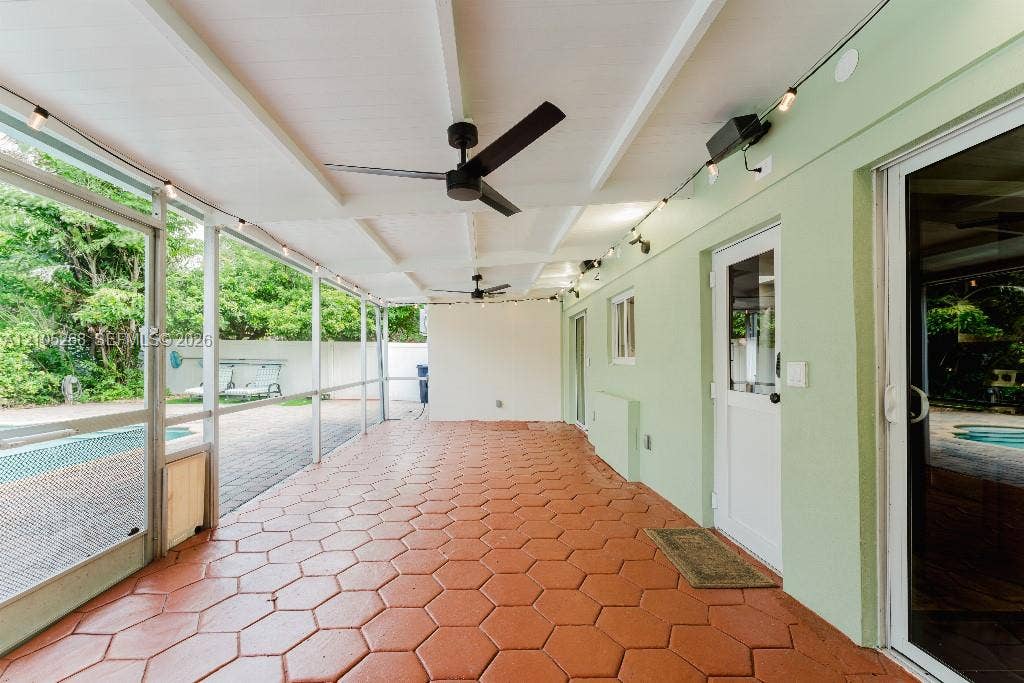 230 Miami Springs Avenue, Miami Springs, FL 33166 Screened patio featuring hexagonal paver flooring, two ceiling fans, and string lighting
