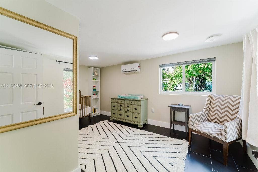 230 Miami Springs Avenue, Miami Springs, FL 33166 Dark-toned flooring, white paneled door, built-in shelving, two overhead lighting fixtures, and a window with natural light