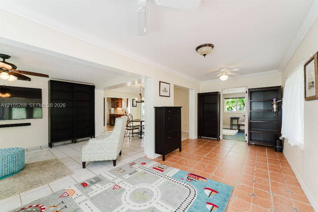 230 Miami Springs Avenue, Miami Springs, FL 33166 Expansive room featuring light tile flooring, crown molding, and two ceiling fans
