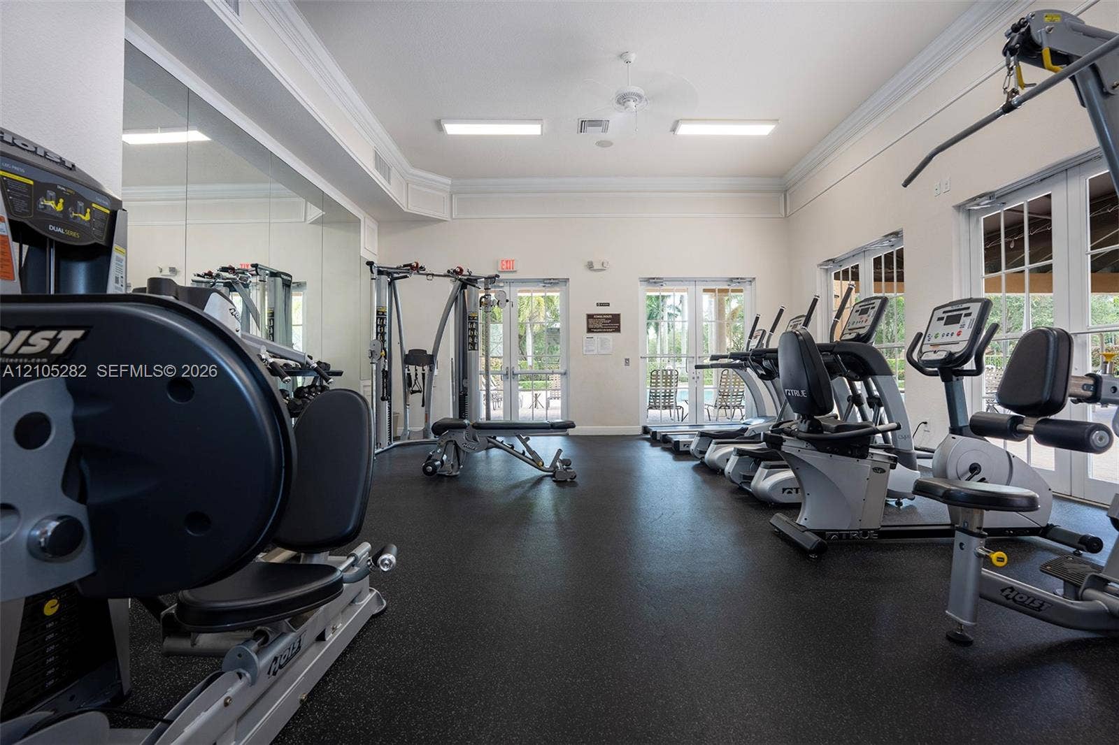 1104 SW 146th Terrace, Pembroke Pines, FL 33027 Fitness center featuring rubber flooring, floor-to-ceiling mirrored walls, crown molding, and dual glass-paned double doors