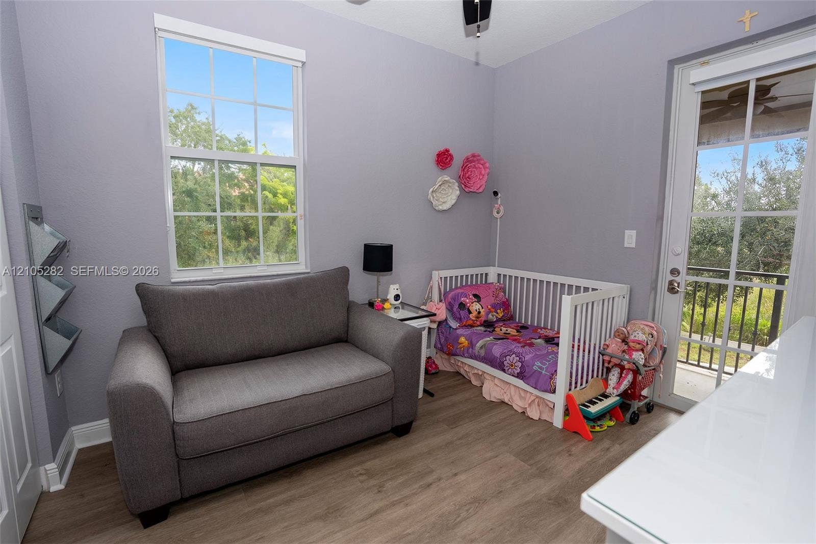 1104 SW 146th Terrace, Pembroke Pines, FL 33027 Room featuring wood-finish flooring, a multi-pane window, and a glass-panel door providing exterior access