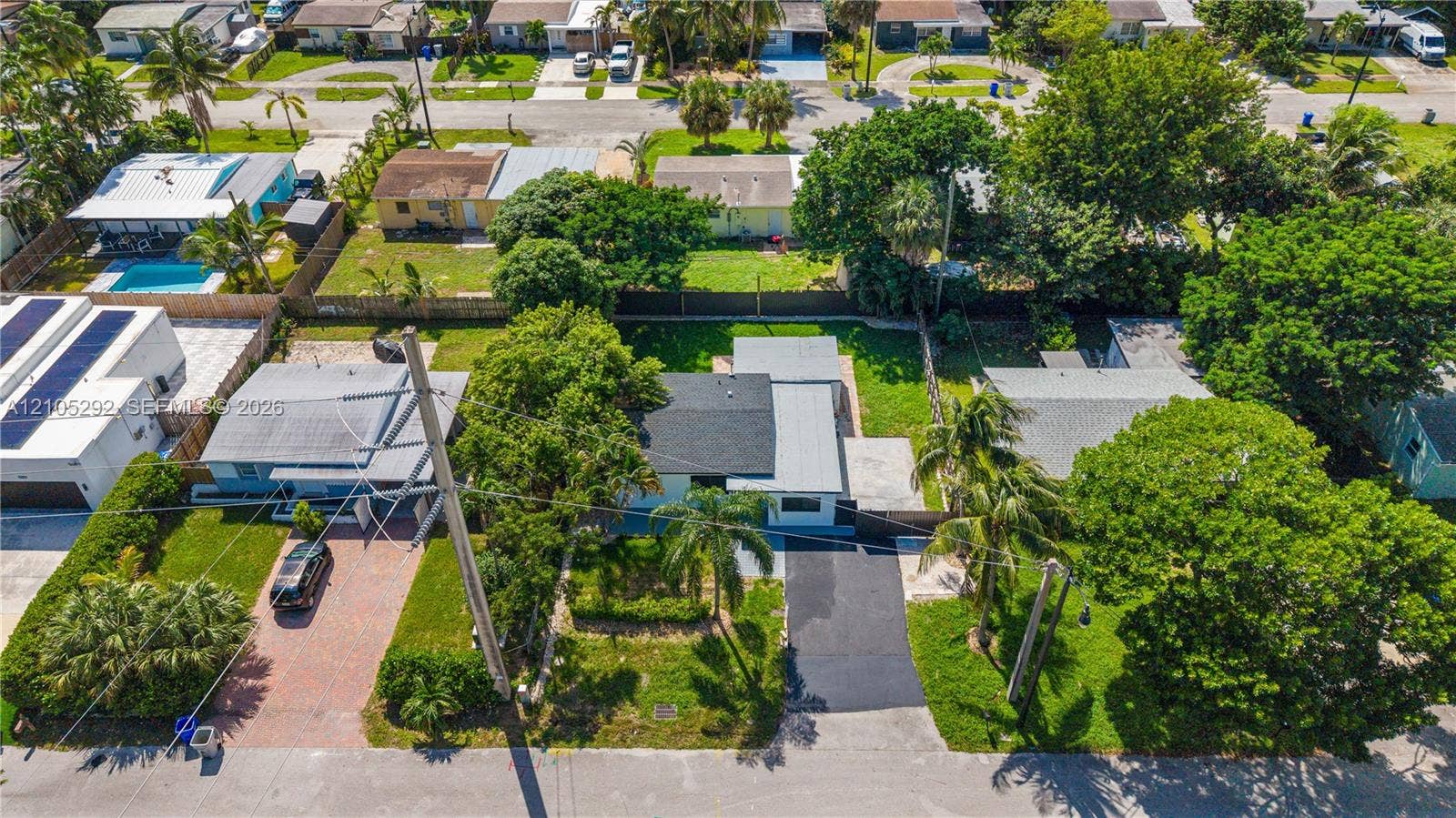 Residential property featuring a shingle roof and mature trees