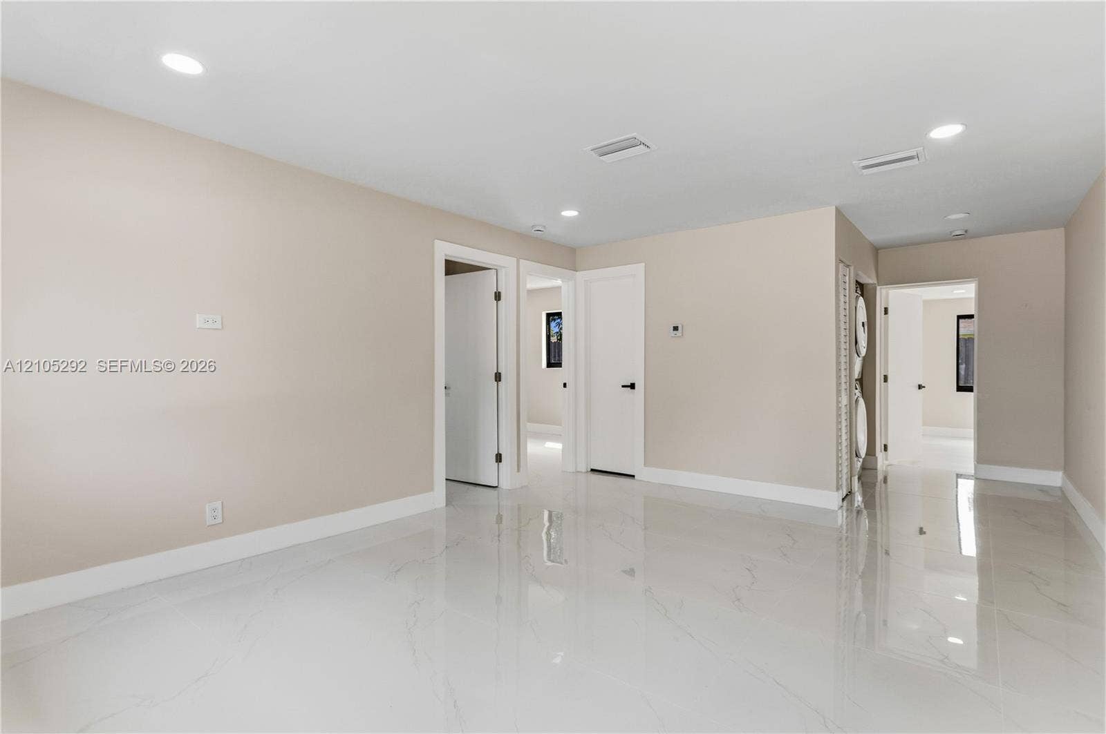 Recessed lighting illuminates the neutral wall tones and white trim