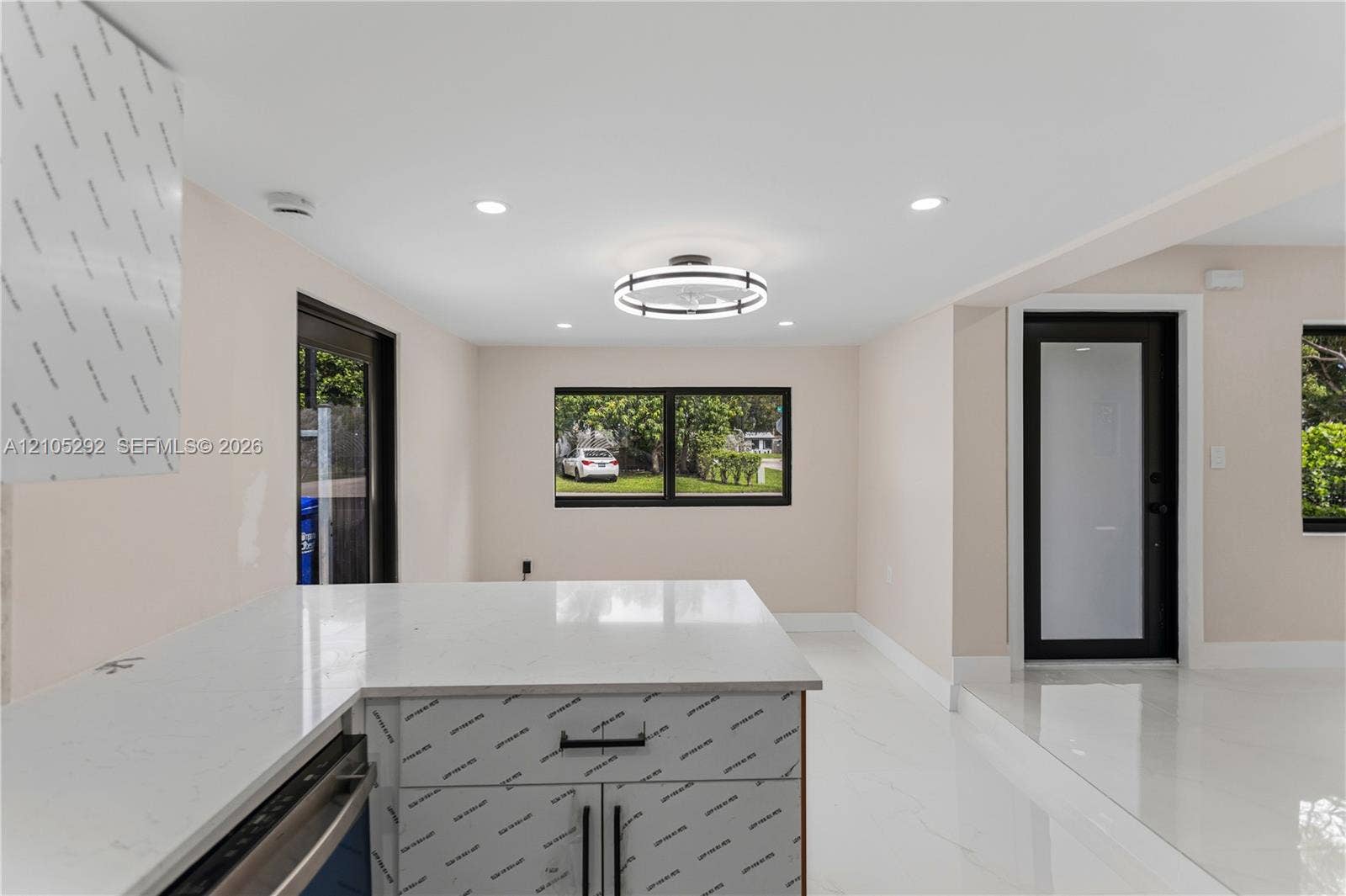 White countertop island with built-in cabinetry and matte black hardware