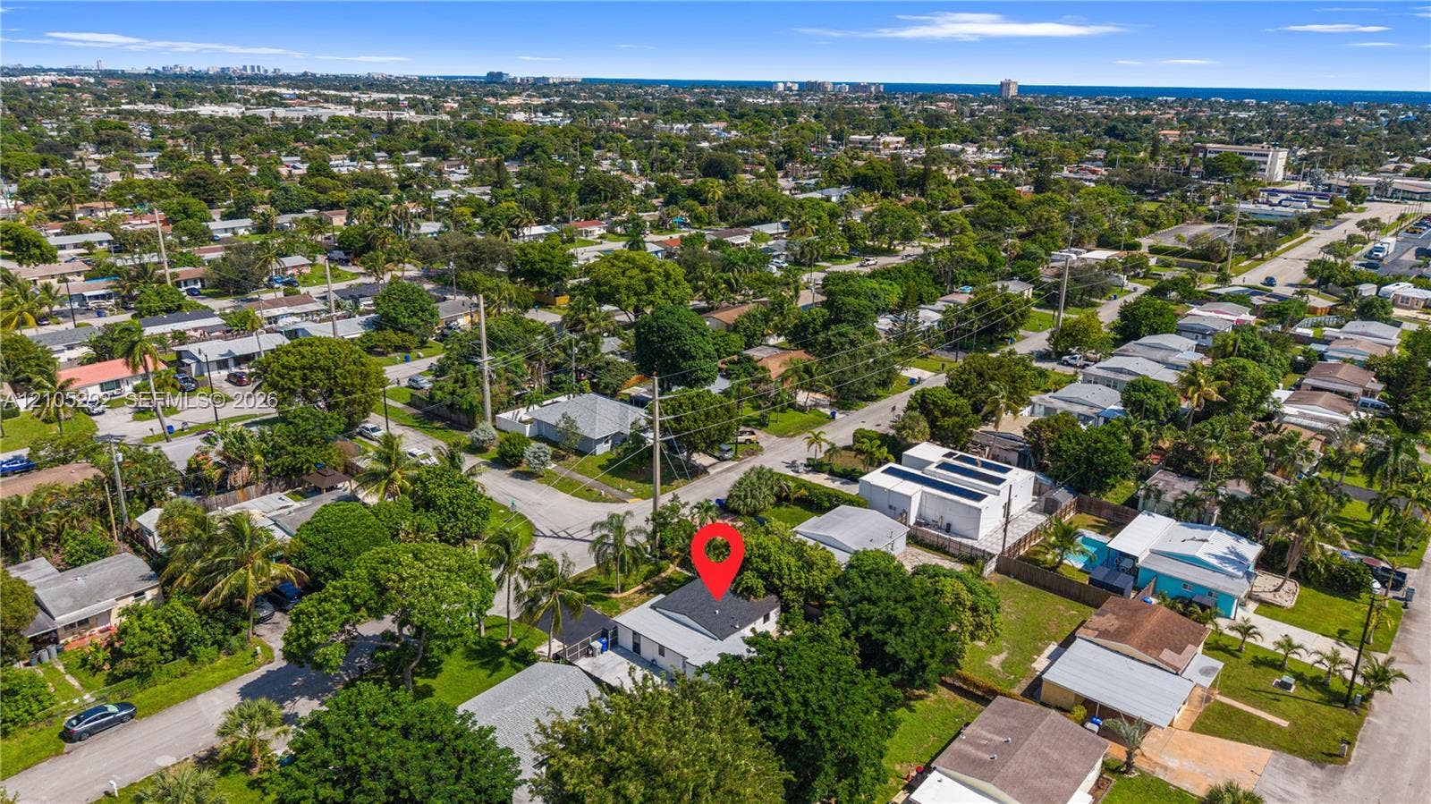 Aerial perspective of a residential neighborhood with a distant body of water