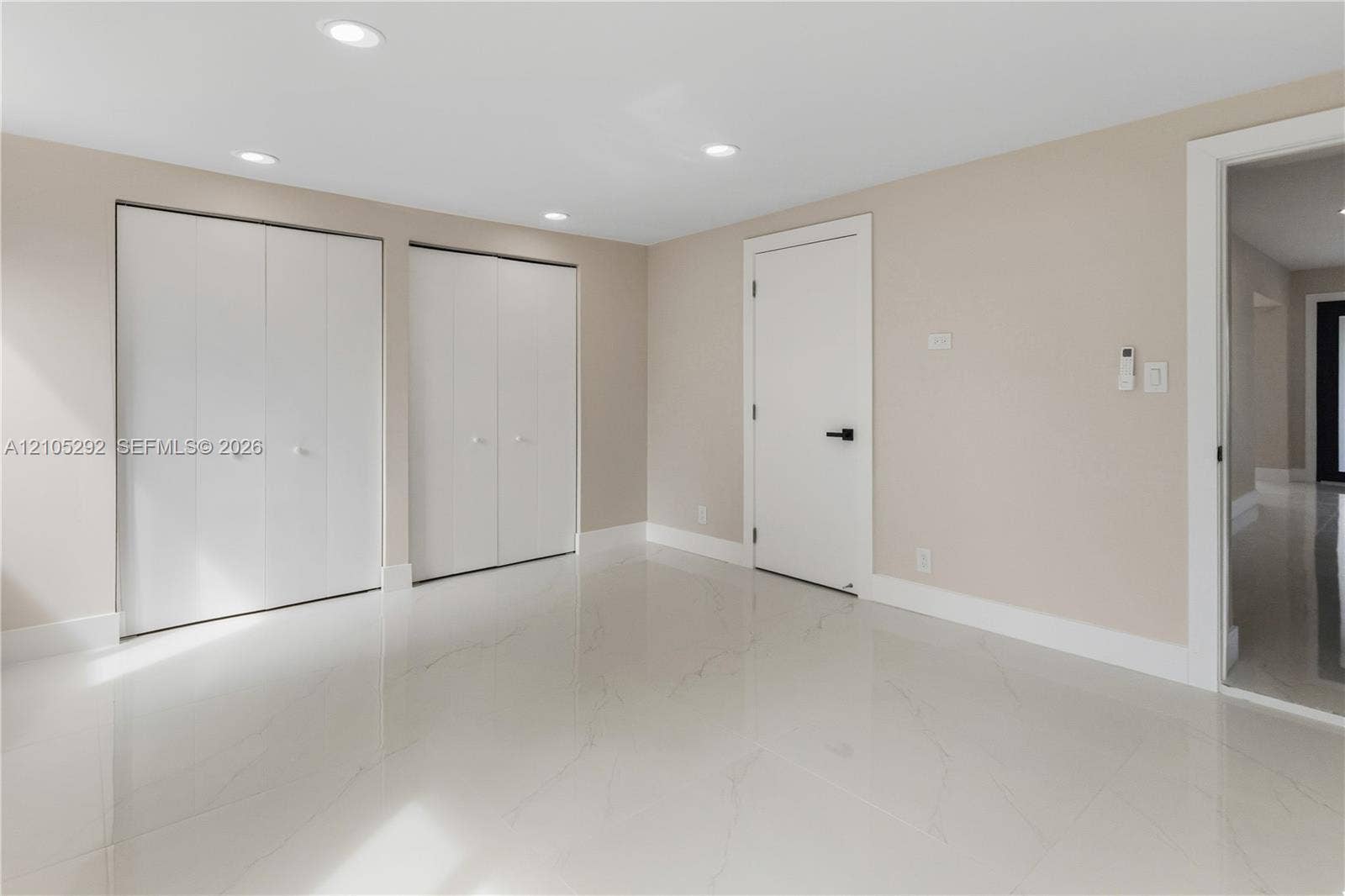 Recessed lighting, light-toned walls, and white tile flooring