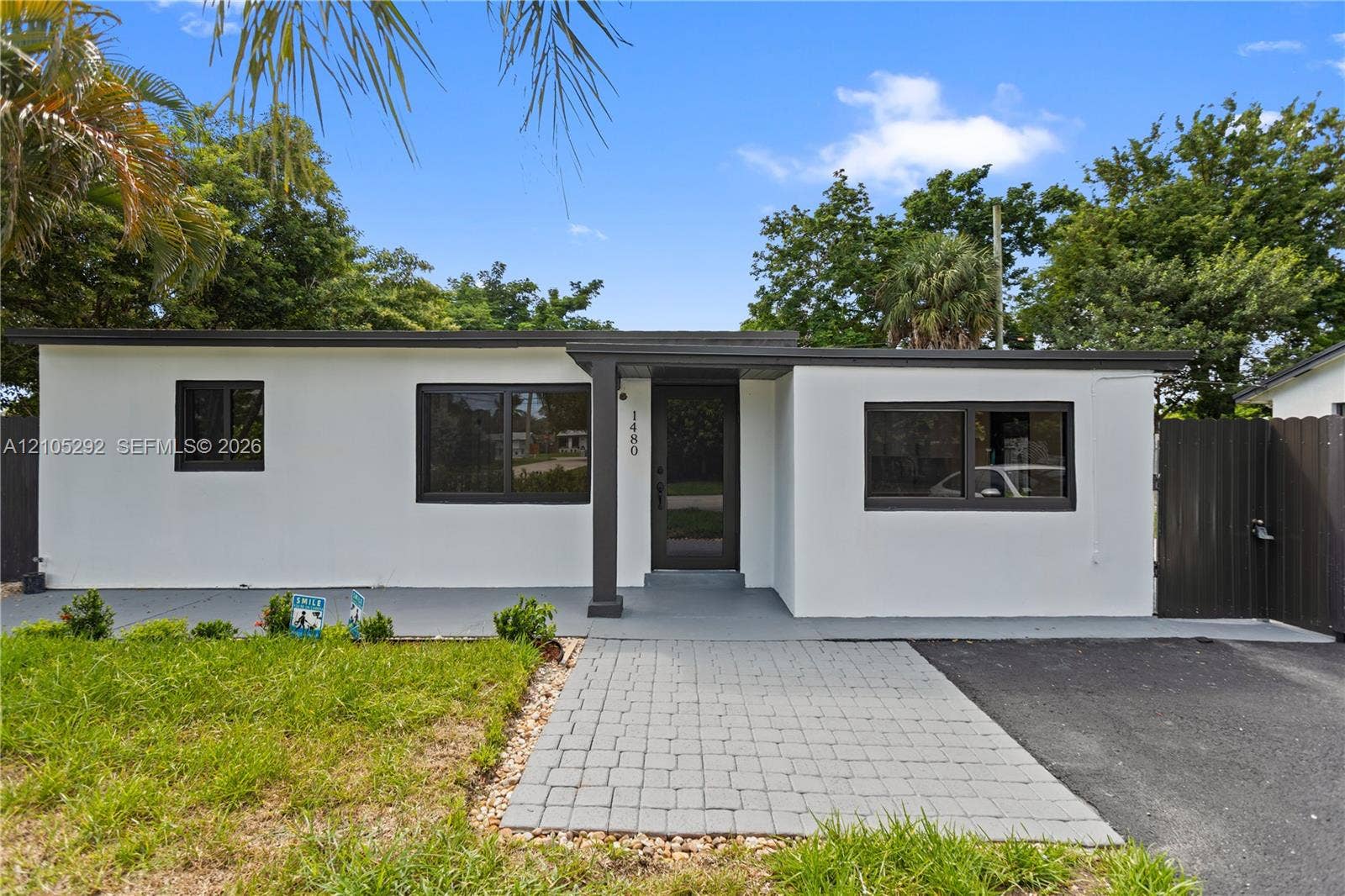 Modern exterior with a white stucco finish, dark trim, and a flat roofline