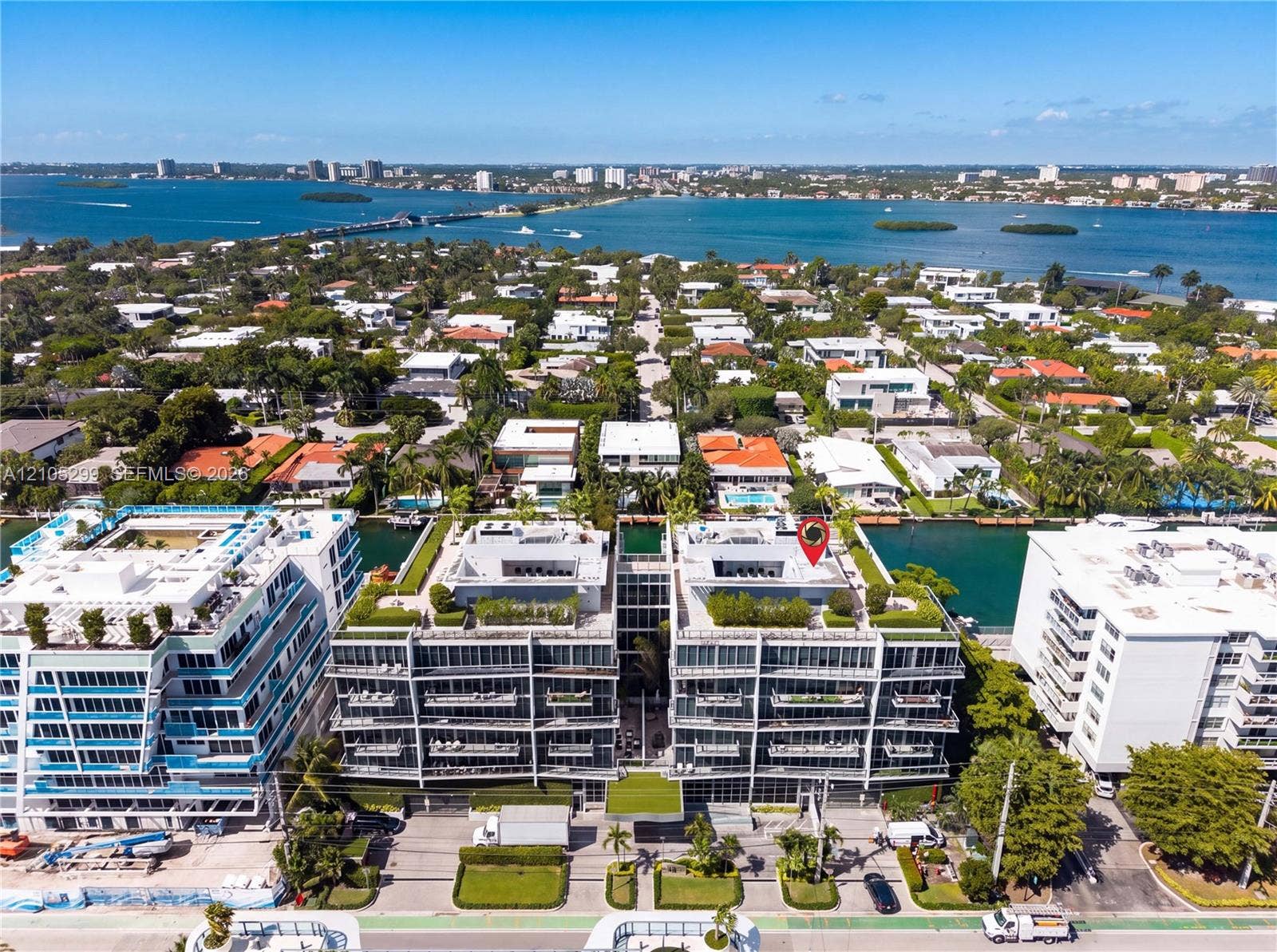 Modern multi-story structure with multiple balconies, rooftop landscaping, and direct water access