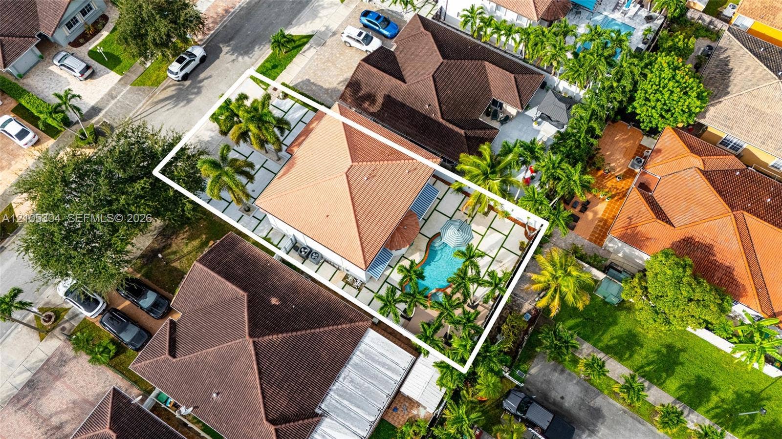 15217 SW 36th Terrace, Miami, FL 33185 Aerial perspective featuring a tile roof, an in-ground swimming pool, and a hardscaped patio with concrete pavers