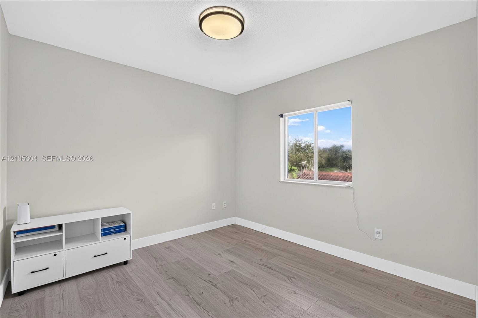 15217 SW 36th Terrace, Miami, FL 33185 Neutral-toned interior featuring wood-finish flooring, a flush-mount ceiling light fixture, and a single-hung window