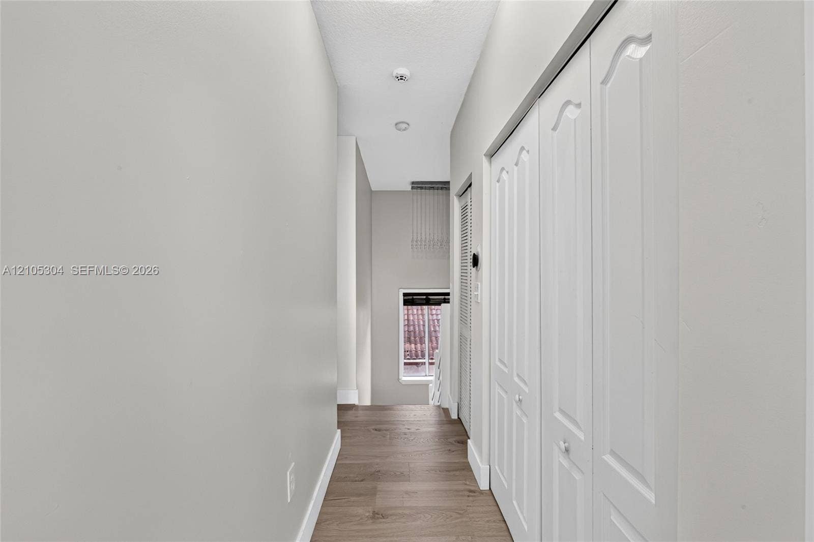 15217 SW 36th Terrace, Miami, FL 33185 Hallway featuring wood-finish flooring, white paneled closet doors, and recessed ceiling lighting