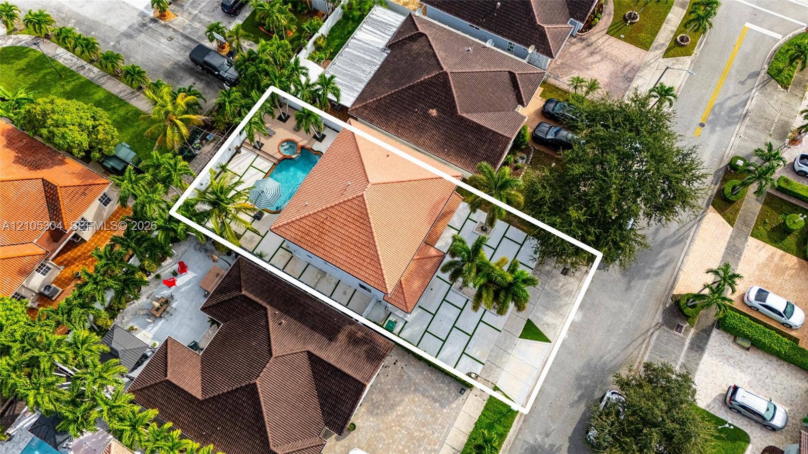 15217 SW 36th Terrace, Miami, FL 33185 Aerial view featuring a tile roof, an in-ground swimming pool with an attached spa, and geometric concrete pavers