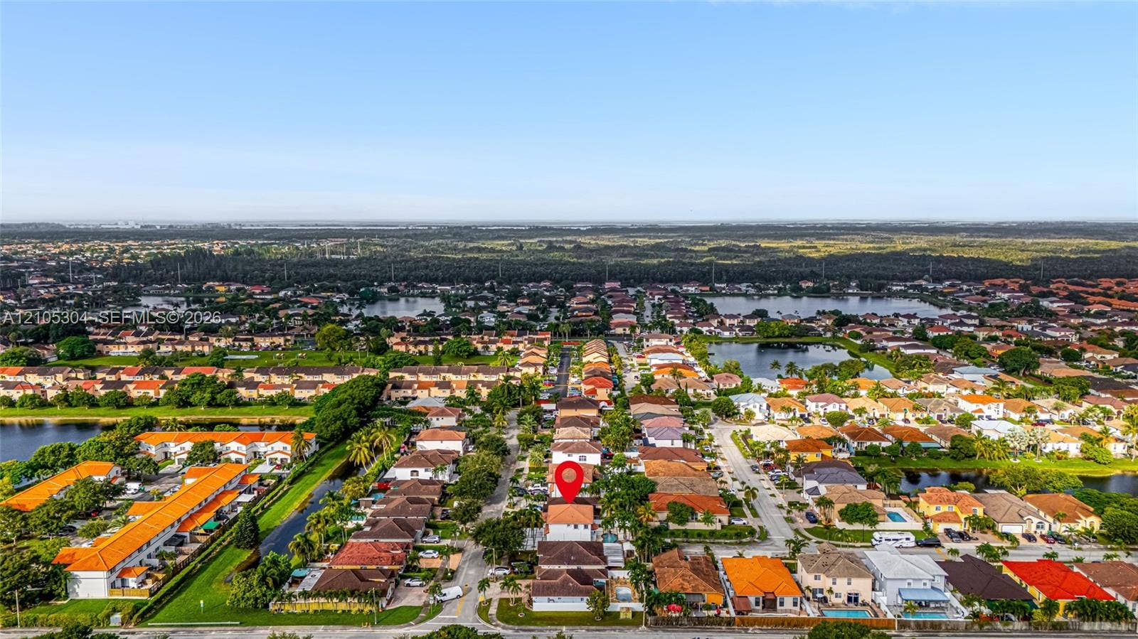 15217 SW 36th Terrace, Miami, FL 33185 Aerial perspective of a multi-story residence featuring a tile roof, paved driveway, and perimeter fencing within a suburban development