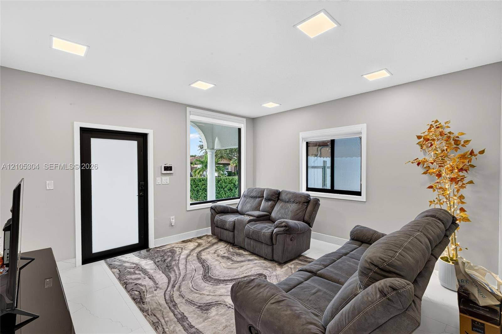15217 SW 36th Terrace, Miami, FL 33185 Interior space featuring neutral wall paint, recessed lighting, large-format tile flooring, and a contrast-framed exterior door