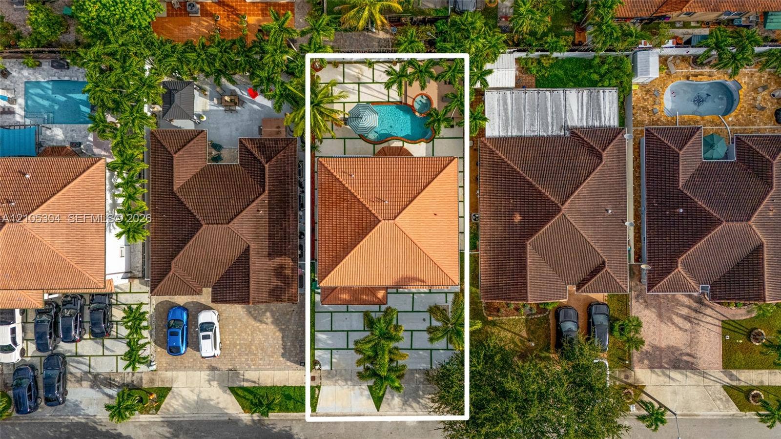 15217 SW 36th Terrace, Miami, FL 33185 Aerial view featuring a tile roof, paved driveway, pool, built-in spa, and concrete grid hardscaping