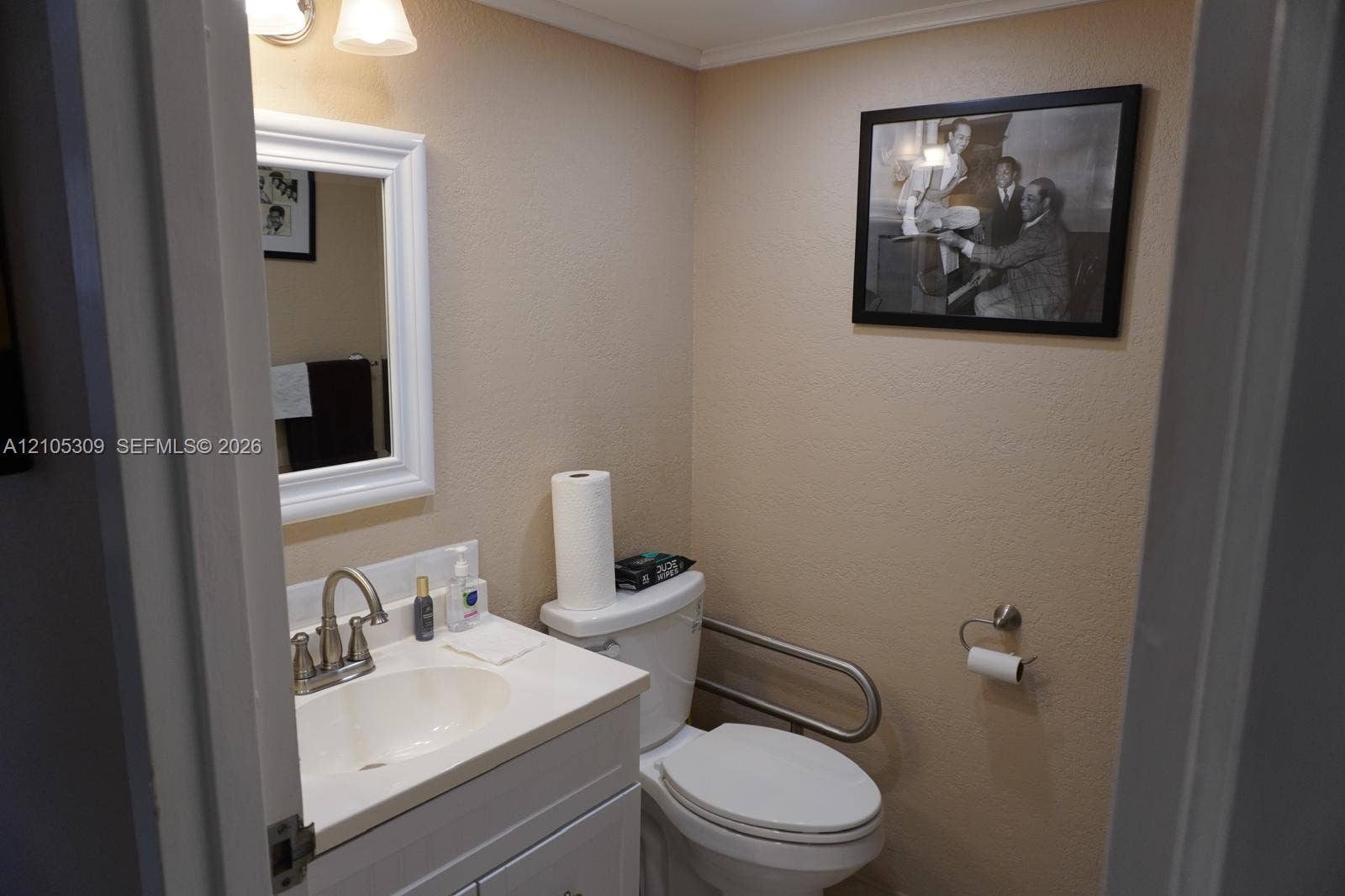 542 Saxony L, #542, Delray Beach, FL 33446 White vanity cabinet with an integrated basin, brushed nickel faucet, wall-mounted mirror, two-light fixture, and wall-mounted metal grab bar