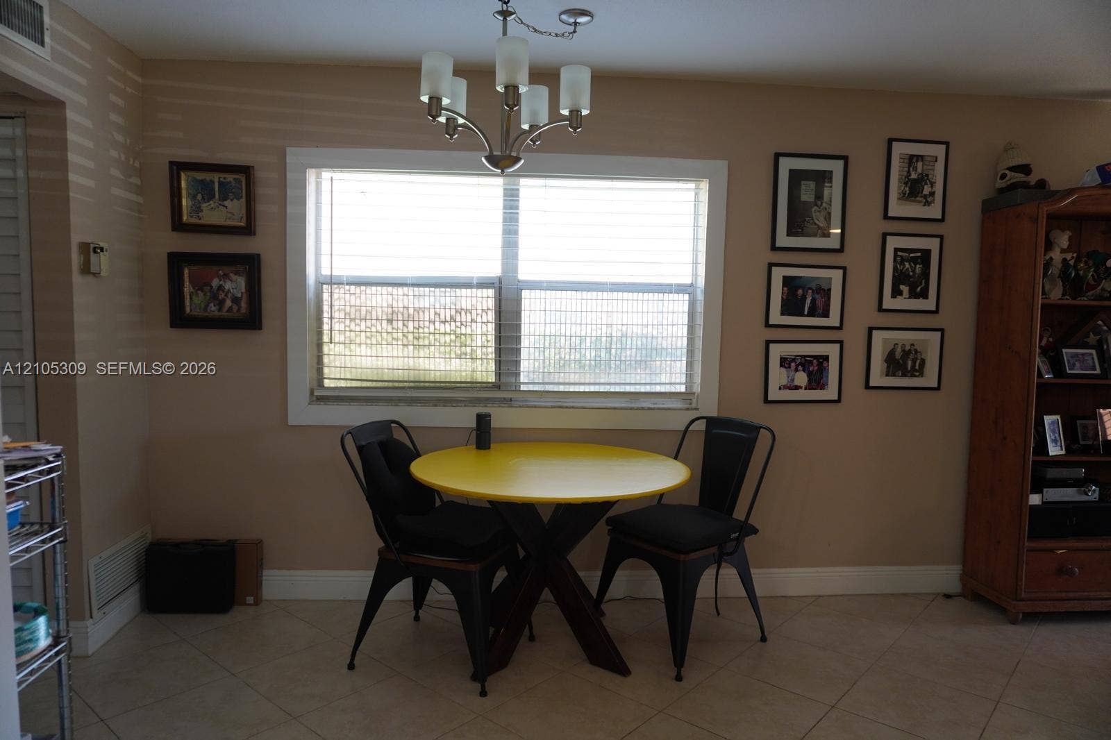 542 Saxony L, #542, Delray Beach, FL 33446 Interior area featuring large window with wide casing, tile flooring, and five-arm chandelier light fixture