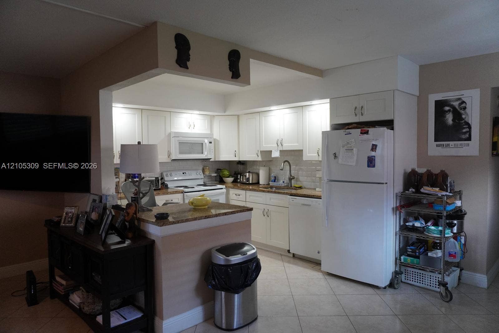 542 Saxony L, #542, Delray Beach, FL 33446 Kitchen featuring white shaker-style cabinetry, stone-finish countertops, tiled backsplash, and built-in appliances including a dishwasher and microwave