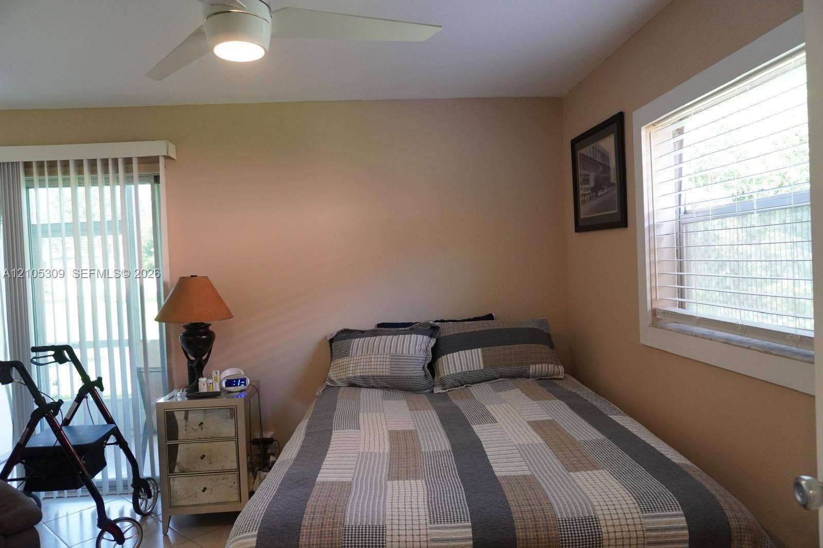 542 Saxony L, #542, Delray Beach, FL 33446 Room featuring neutral wall paint, a ceiling-mounted light fixture with fan, and a sliding glass door with vertical blinds
