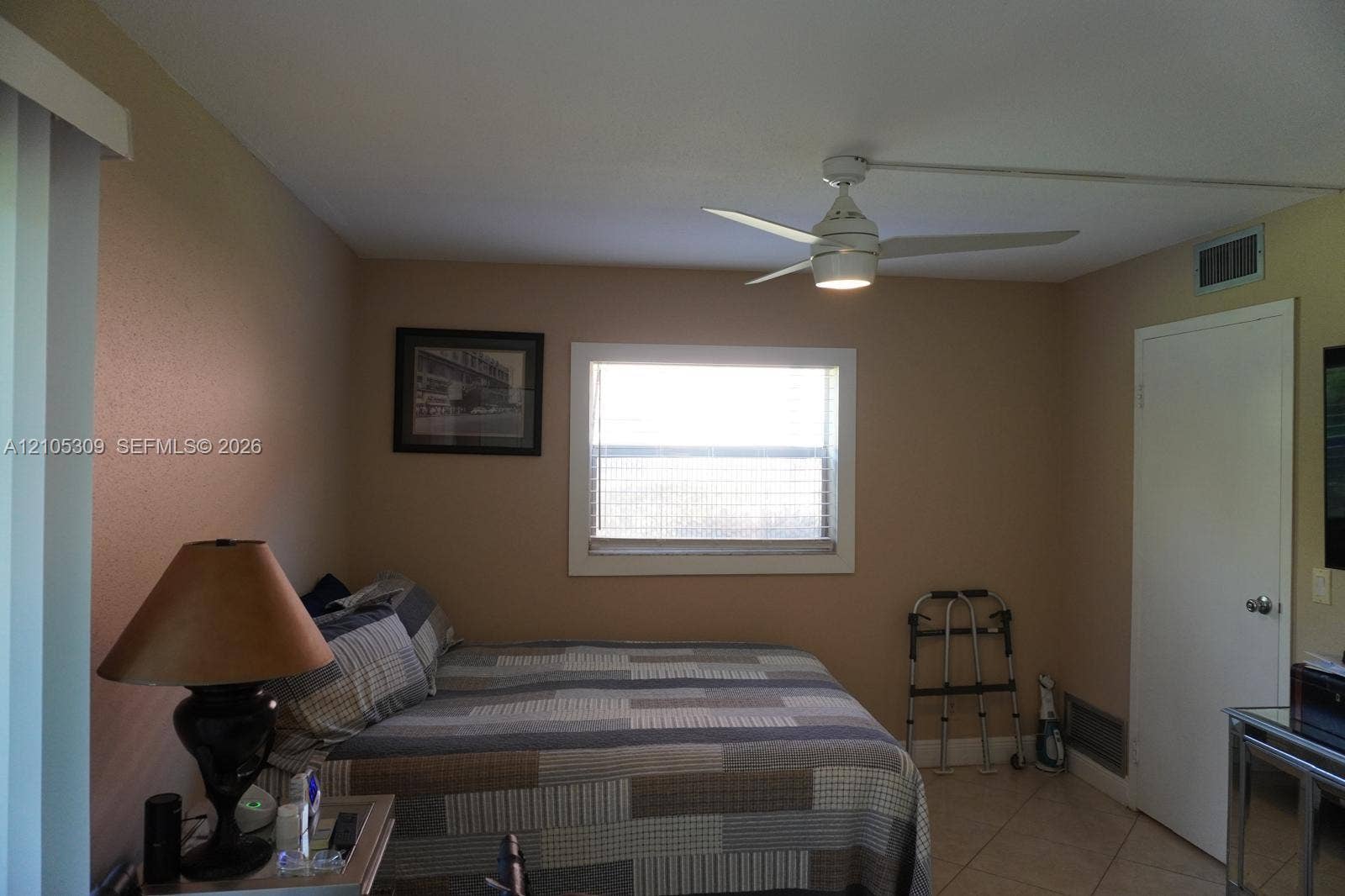 542 Saxony L, #542, Delray Beach, FL 33446 Room featuring a central window, white ceiling fan with integrated lighting, neutral wall paint, and tile flooring