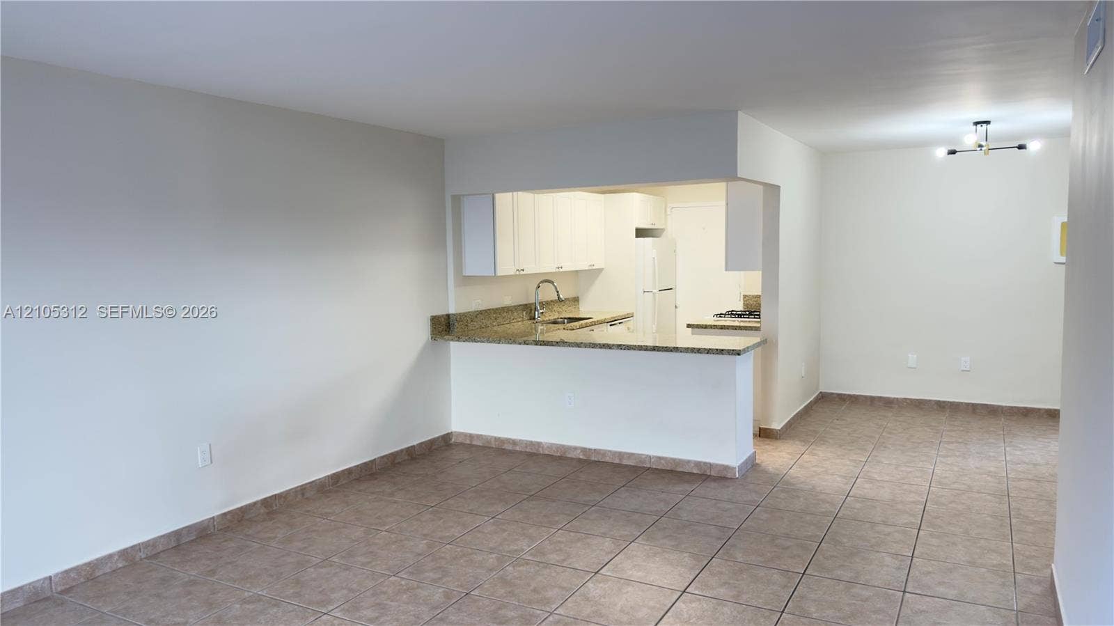 6900 N Kendall Drive, #A304, Pinecrest, Pinecrest, FL 33156 Kitchen featuring stone-finish countertops, white cabinetry, tile flooring, a dual-basin sink with a gooseneck faucet, and a multi-light flush-mount fixture