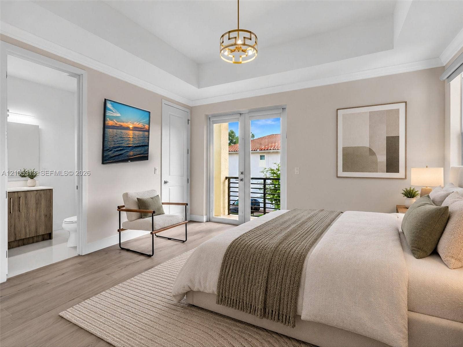 Virtually staged. Tray ceiling, wood-finish flooring, metal-frame geometric pendant light, and glass-paned double doors with access to a railed balcony