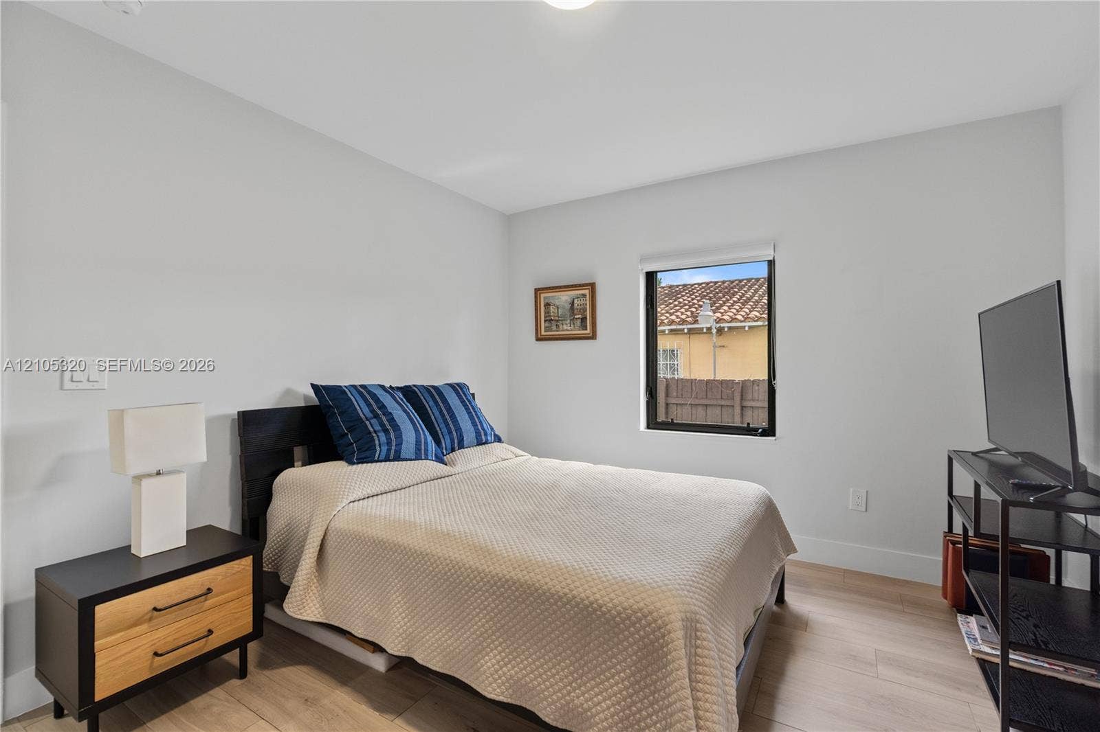 Recessed ceiling lighting, light wood-finish flooring, a contemporary window, and white wall finishes