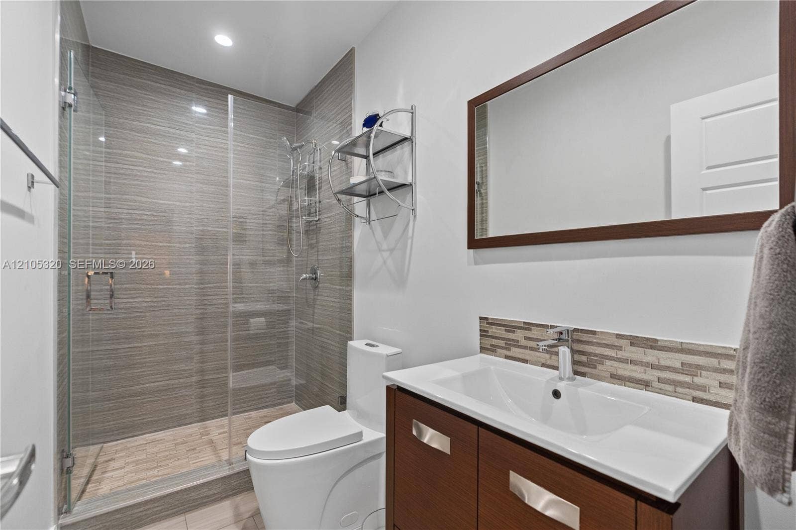 Glass-enclosed shower with horizontal-patterned wall tile