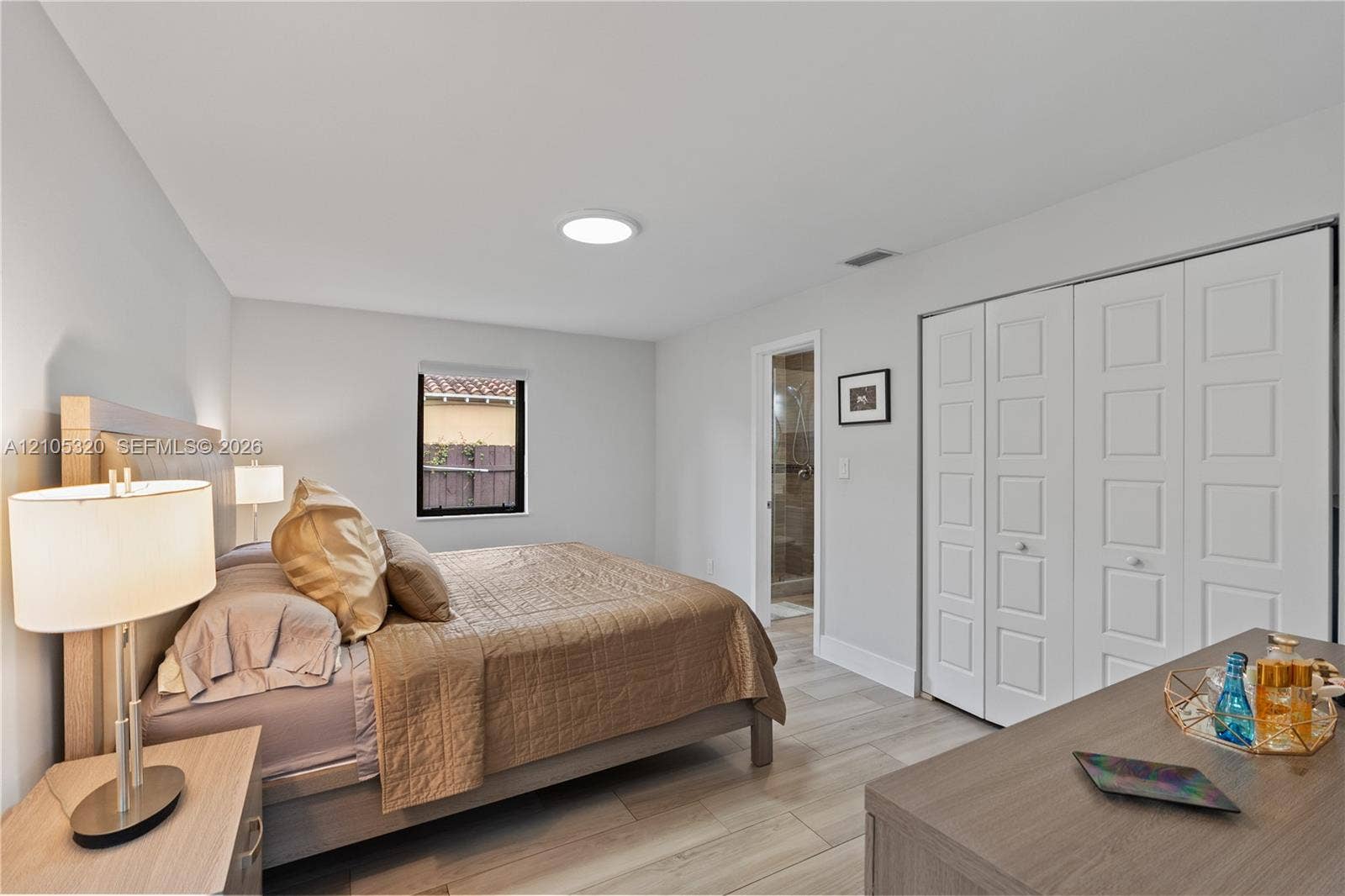 Wood-finish flooring, white walls, built-in closet with paneled doors, and a recessed ceiling light
