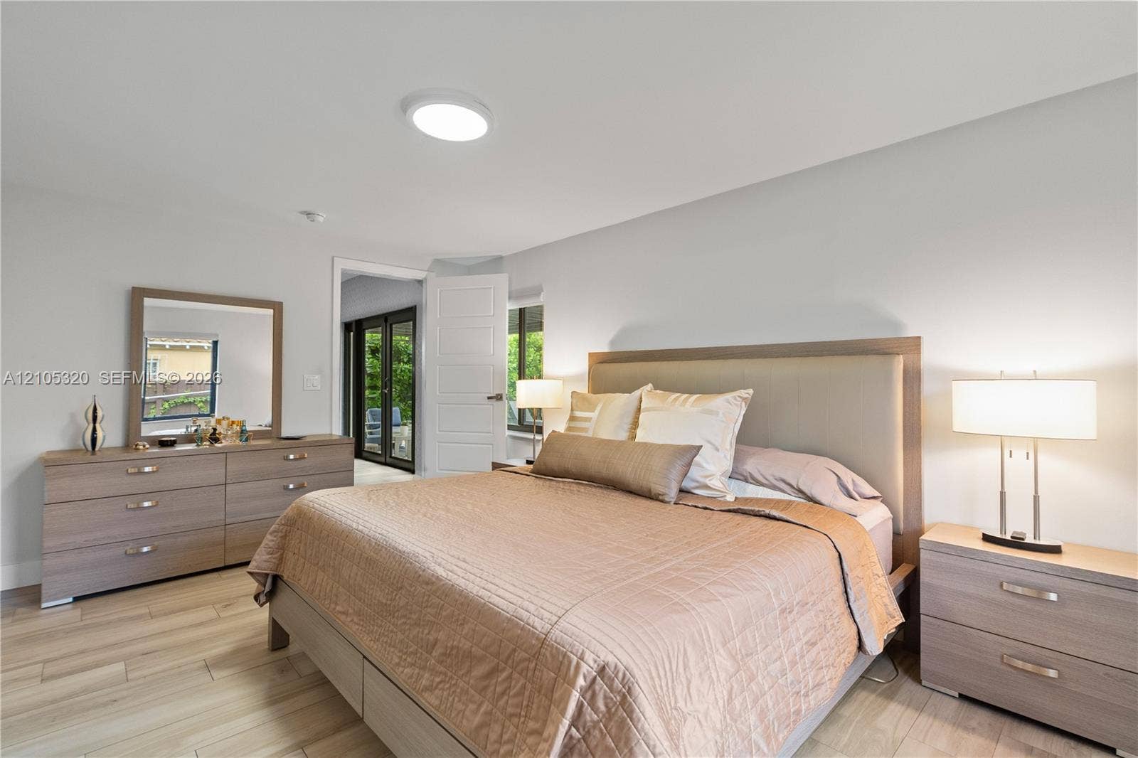 Recessed lighting, light wood-finish flooring, and a panel door leading to outdoor space
