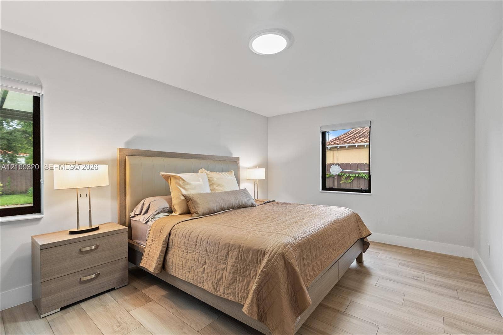 Light wood-finish flooring, recessed ceiling light, and multiple windows with dark frames