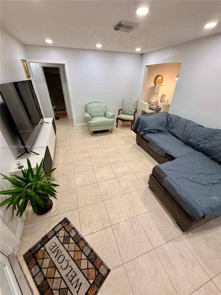Recessed lighting, light-toned tile flooring, and white baseboards