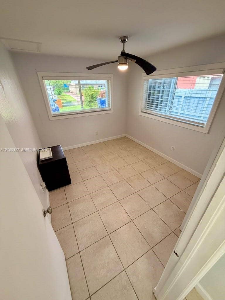 Tile flooring, ceiling fan with integrated lighting, and two windows with blinds