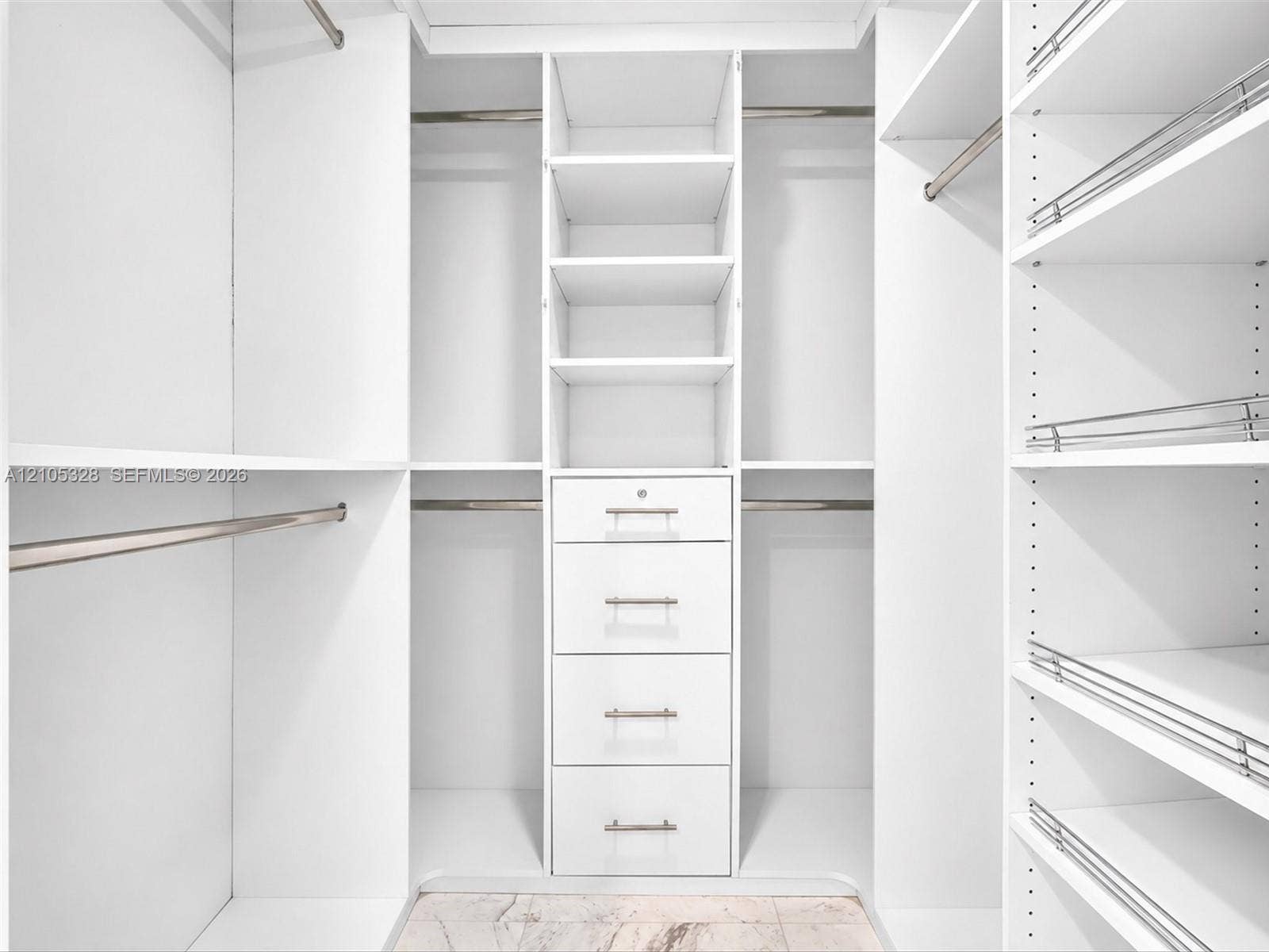 3951 S Ocean Drive, #1901, Hollywood, FL 33019 Luxurious custom-designed white closet system featuring generous hanging space, adjustable shelving, and built-in drawers with polished hardware for elegant, organized storage.