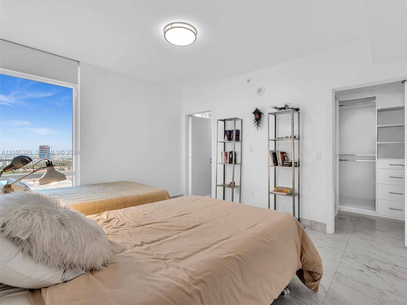 3951 S Ocean Drive, #1901, Hollywood, FL 33019 Bright and elegantly appointed interior featuring an expansive window that fills the space with natural light, a custom built-in closet organization system, polished stone flooring, crisp white walls, and recessed ceiling lighting.