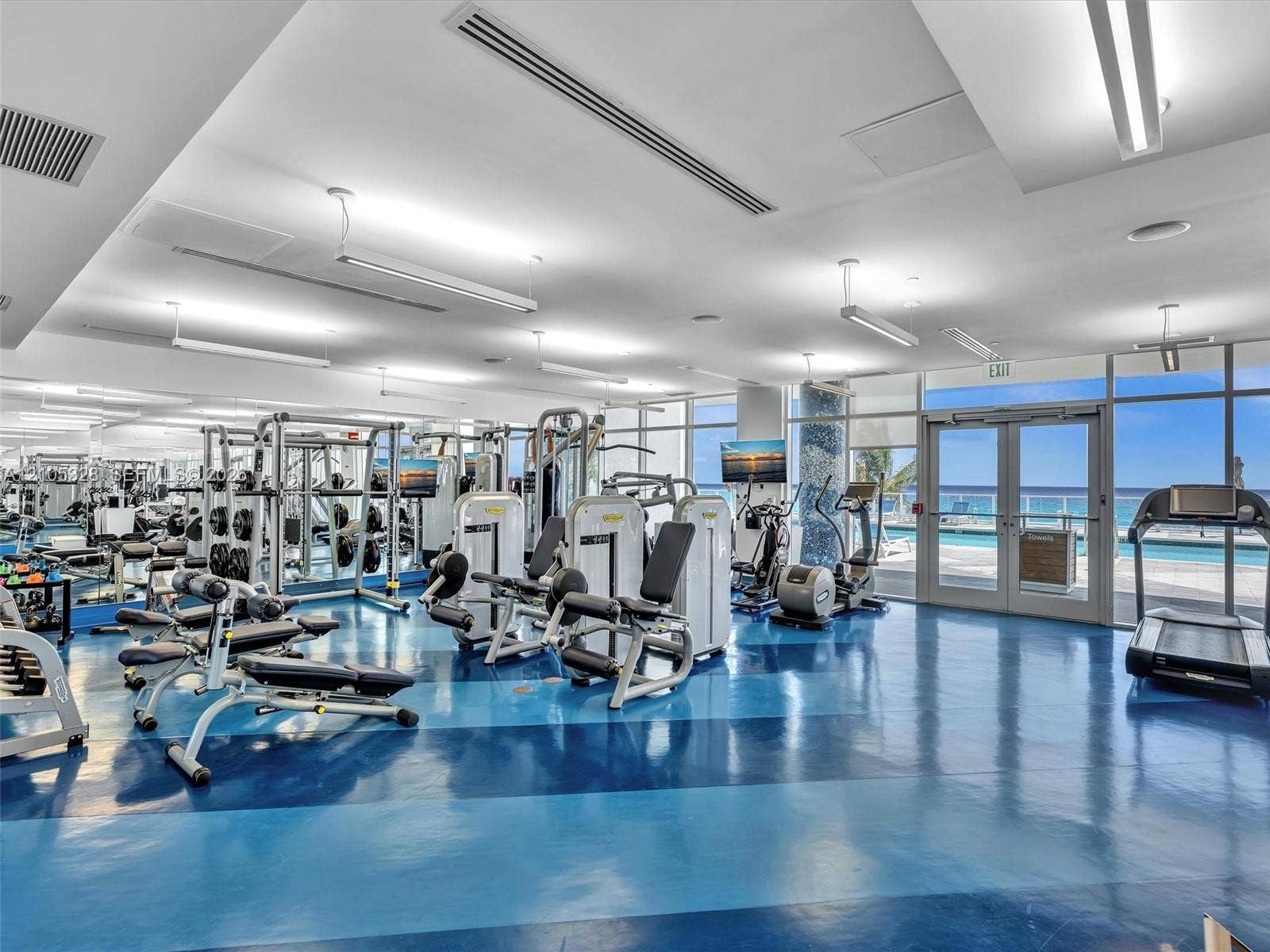 3951 S Ocean Drive, #1901, Hollywood, FL 33019 Expansive fitness center featuring a blue and dark blue patterned floor, floor-to-ceiling windows, and abundant natural light