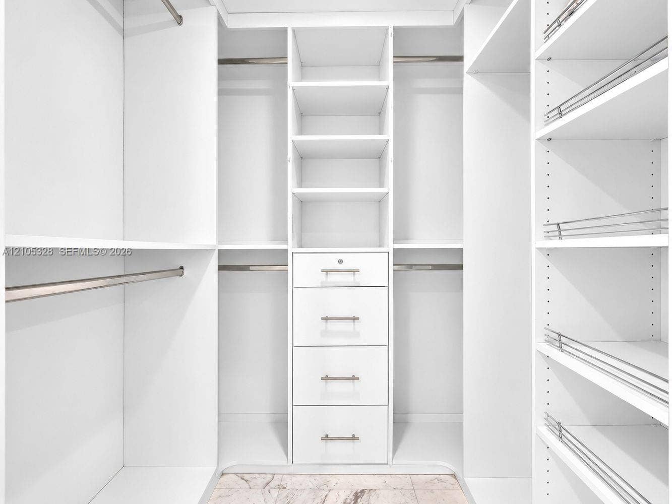 3951 S Ocean Drive, #1901, Hollywood, FL 33019 Custom-designed closet featuring ample hanging space, built-in shelving, and a five-drawer storage unit with brushed nickel hardware.